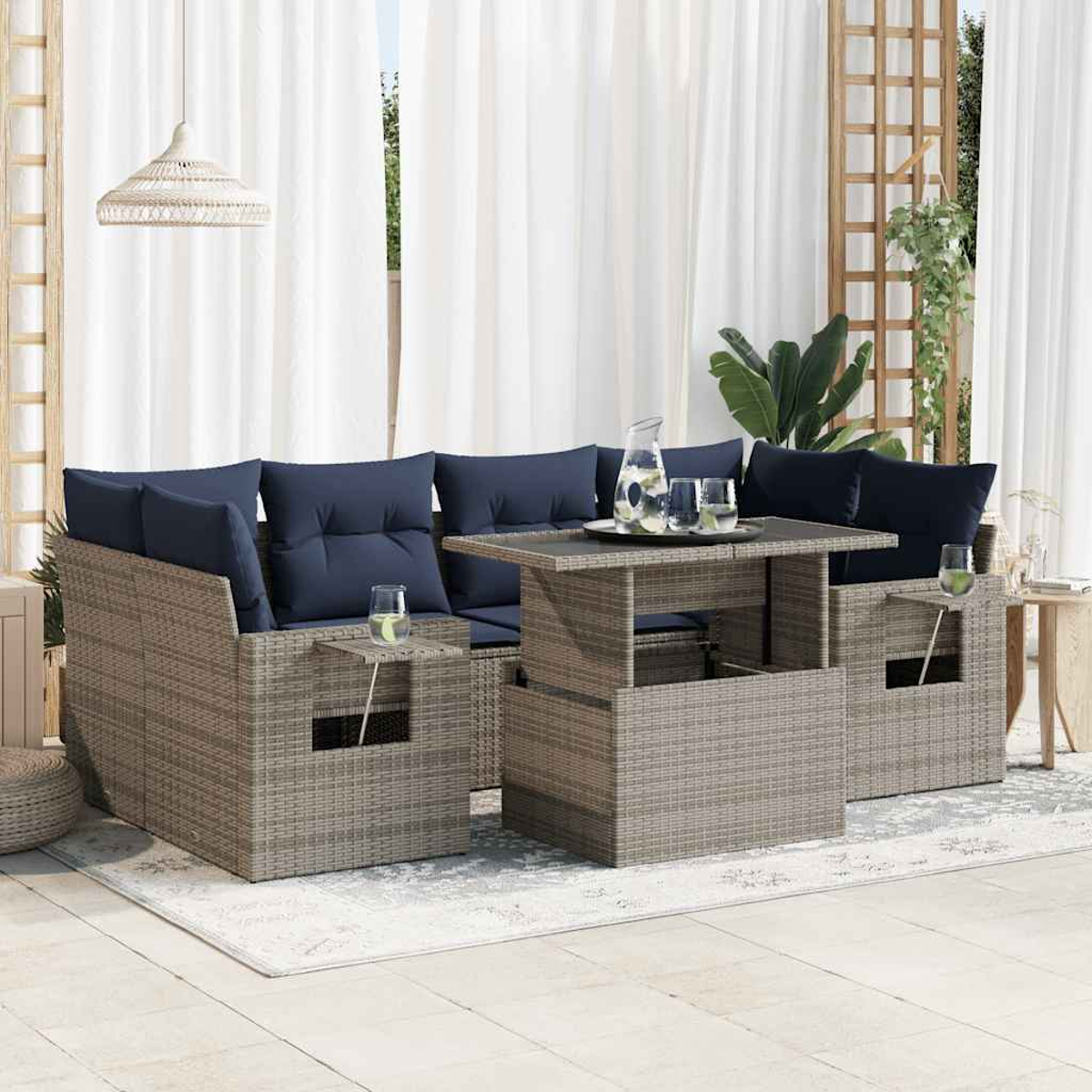 Sofá seccional de ratán con cojines azules y una mesa. La escena tiene lugar en un jardín. Gris.