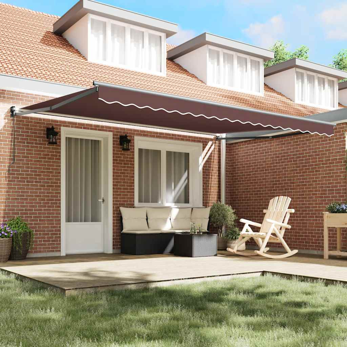 Eine braune Markise erstreckt sich über eine Terrasse mit Möbeln. Eine Backsteinmauer bildet den Hintergrund. Ein Haus mit Dachgauben ist im Hintergrund.