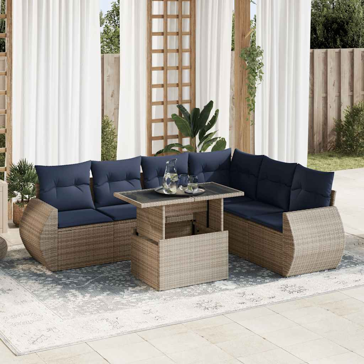 Ein Outdoor-Korbsofa-Set mit blauen Kissen und einem Tisch. Weiße Vorhänge im Hintergrund.