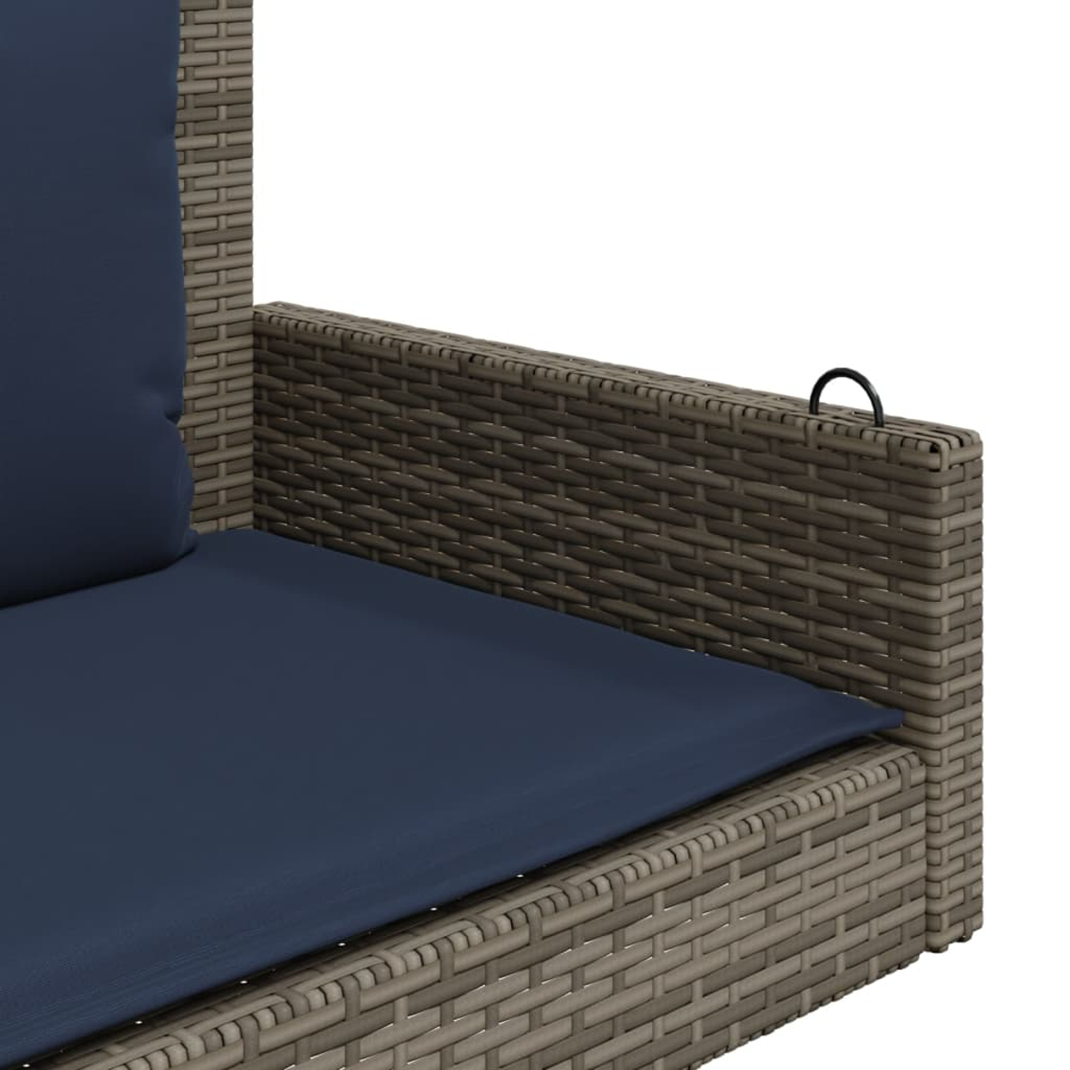 Primo piano del bracciolo del divano in rattan con cuscino blu e anello nero.