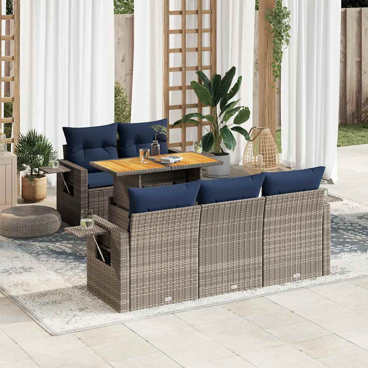 Outdoor-Korbsessel-Set mit blauen Kissen und einem Tisch mit anhebbarer Platte, auf einer Terrasse mit weißen Vorhängen.