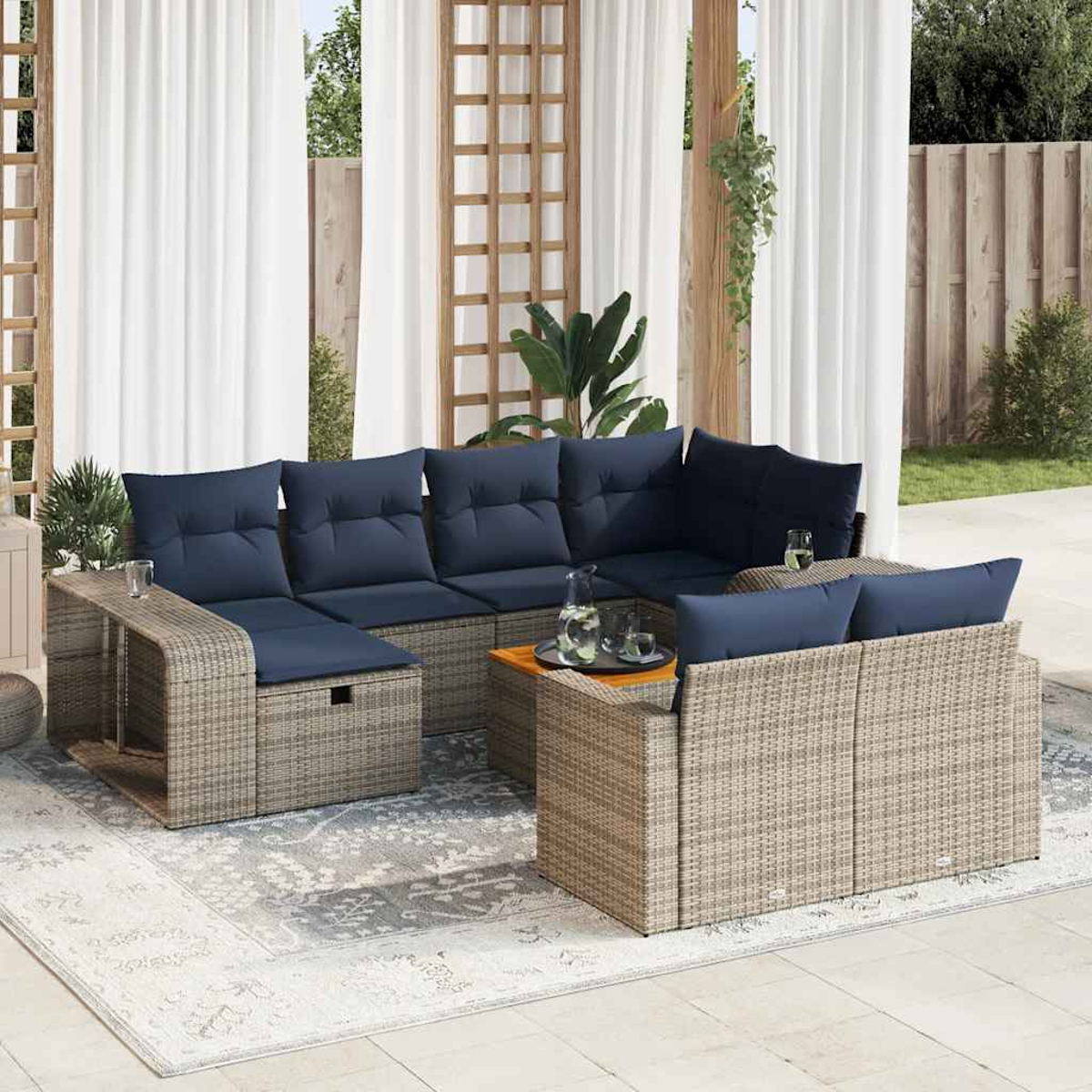 Outdoor-Korbmöbel mit blauen Kissen und Tisch. Vorhänge und Teppich sind vorhanden.