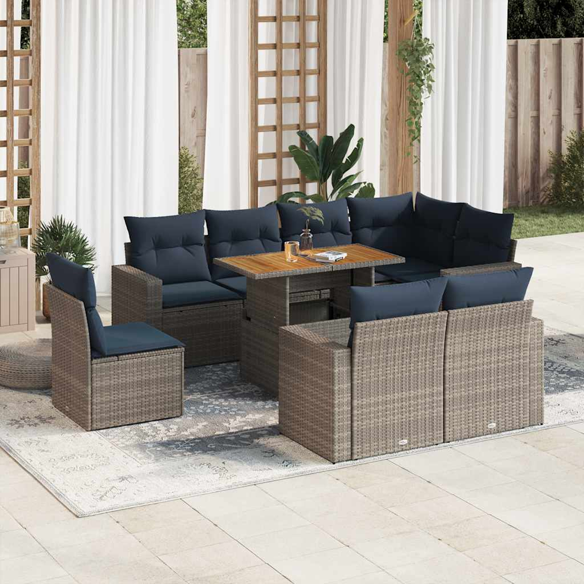 Outdoor-Sitzgruppe mit gewebten Möbeln, blauen Kissen und einem Holztisch. Die Szene enthält Pflanzen und Vorhänge.