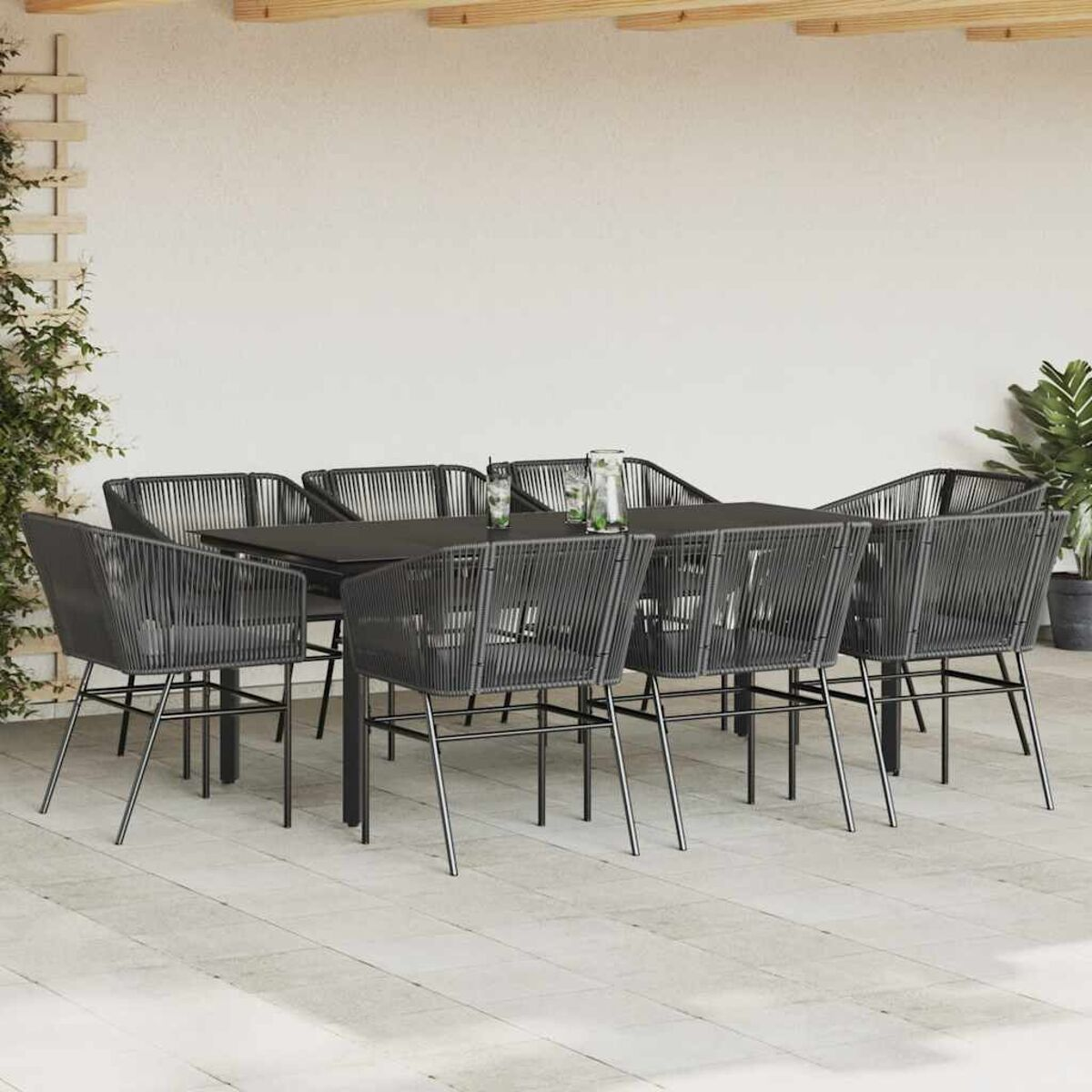 Essgruppe im Freien mit Stühlen und einem Tisch. Die Stühle sind gewebt und der Tisch ist dunkel.