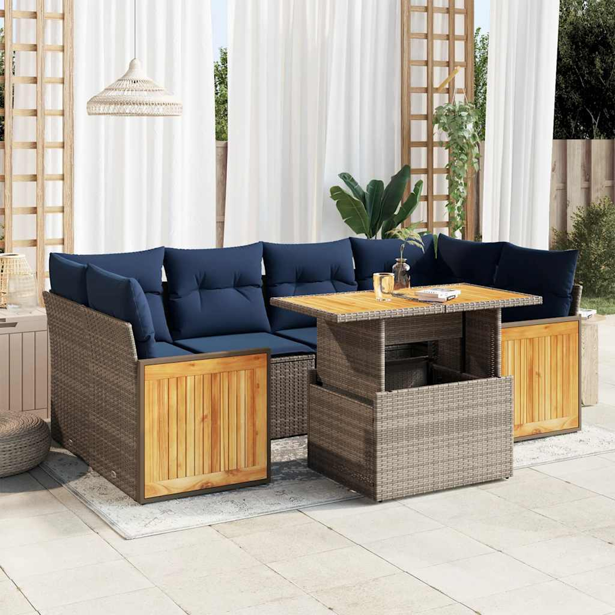 Geflochtenes Ecksofa mit blauen Kissen, Holzakzenten und Tisch auf Terrasse.