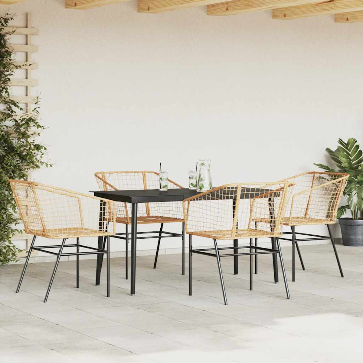 Eine Essgruppe im Freien mit einem schwarzen Tisch und vier gewebten Stühlen vor einer weißen Wand.