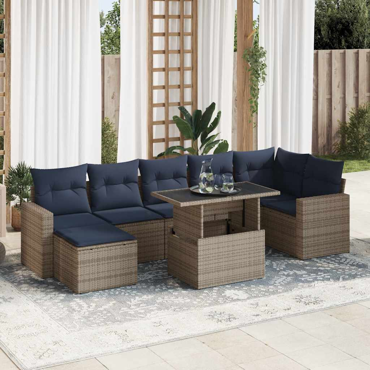 Outdoor-Sitzgruppe mit blauen Kissen und einem Holztisch. Der Hintergrund zeigt einen Garten.
