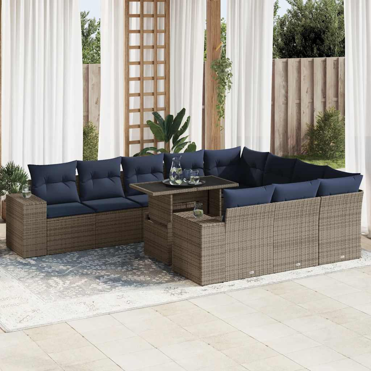 Outdoor-Ecksofa mit grauem Korbgeflecht, marineblauen Kissen, einem ansteigenden Tisch und einem gemusterten Teppich.