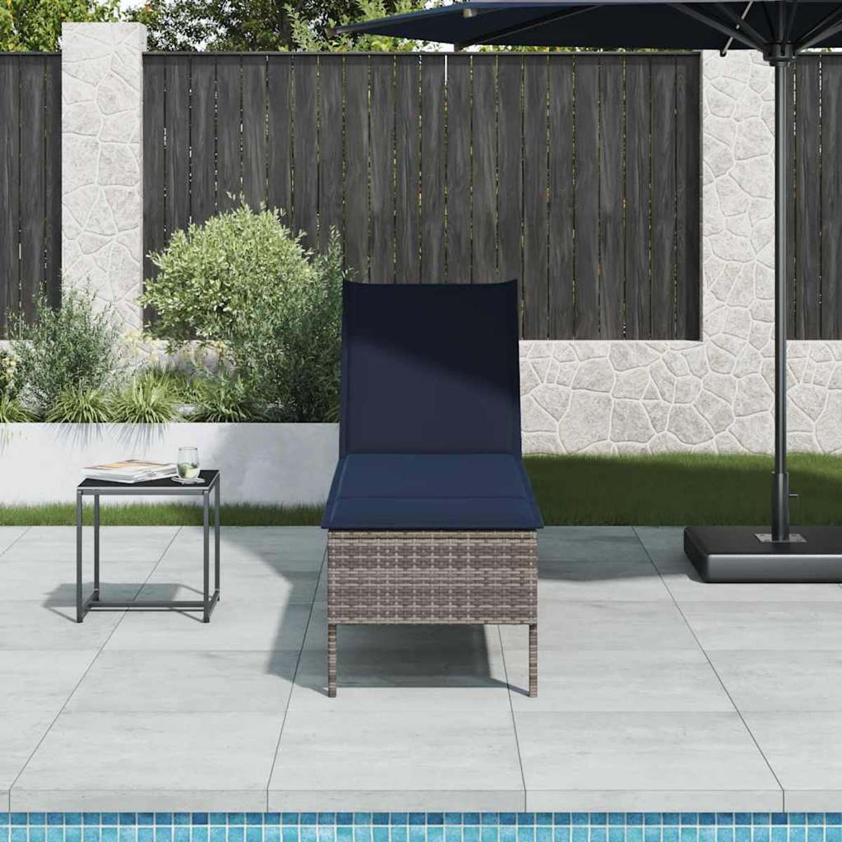Outdoor-Liegestuhl mit grauem Korbgeflecht, marineblauem Kissen, kleinem schwarzem Tisch und geschlossenem Schirm.