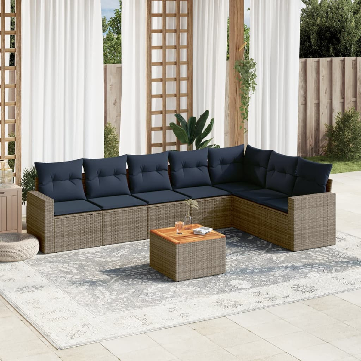 Korbmöbel-Sofa-Set mit blauen Kissen, Holztisch und Teppich, Outdoor-Setting.