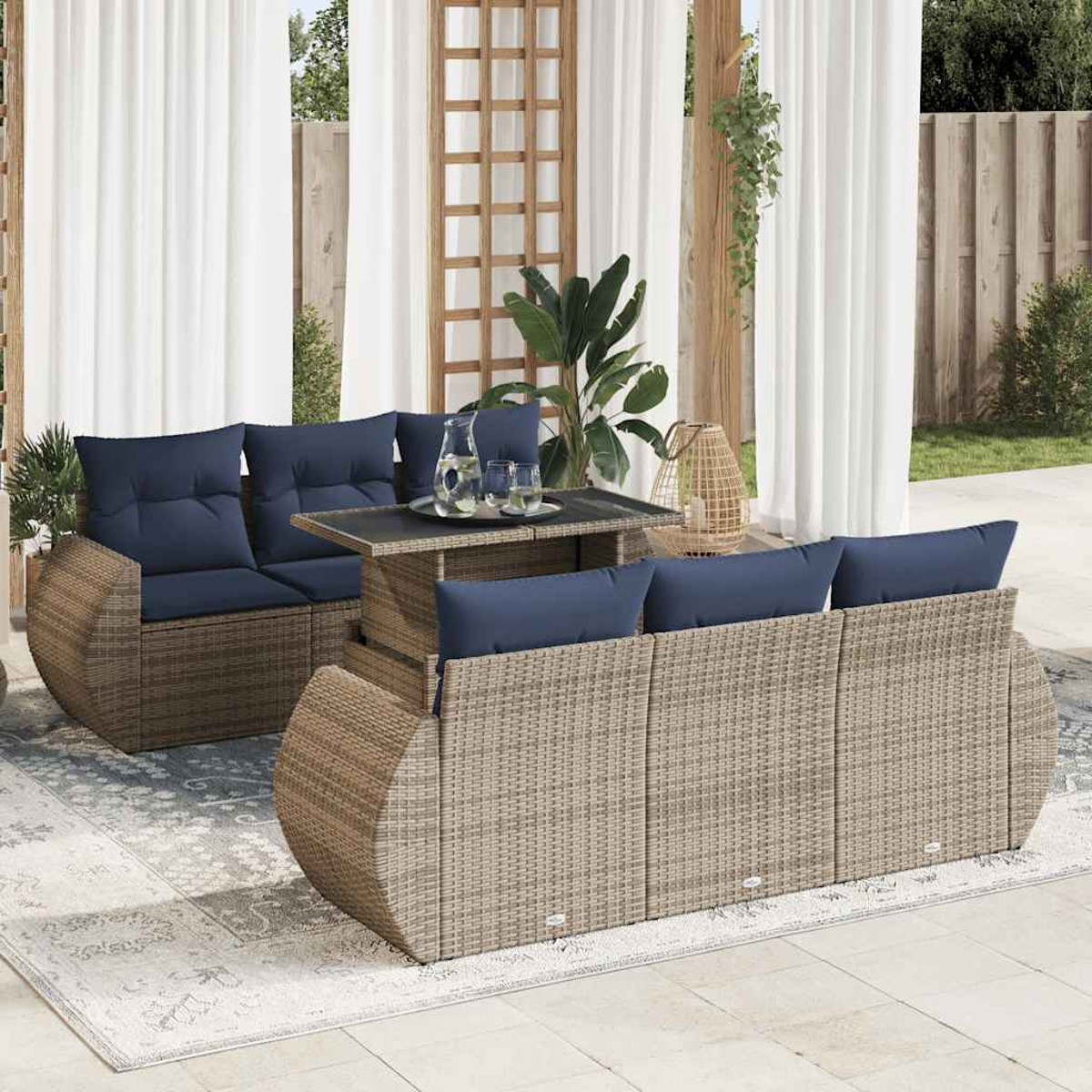 Rattansofa mit blauen Kissen, ein Tisch mit Glasplatte und Vorhänge im Hintergrund.