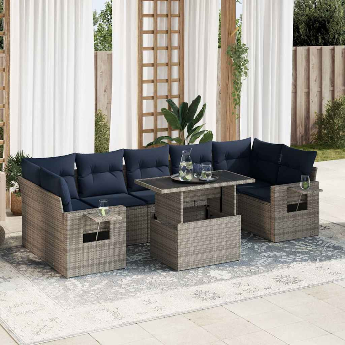 Rattan-Gartenmöbel mit blauen Kissen, einem Tisch mit Hubplatte und Gläsern auf der Terrasse.