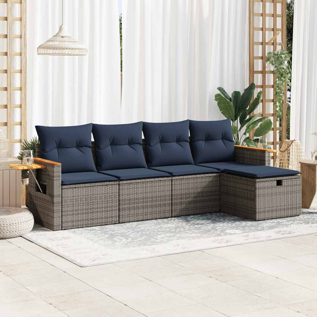 Gartenmöbel mit Sofa mit blauen Kissen, einem kleinen Tisch und einem Teppich.