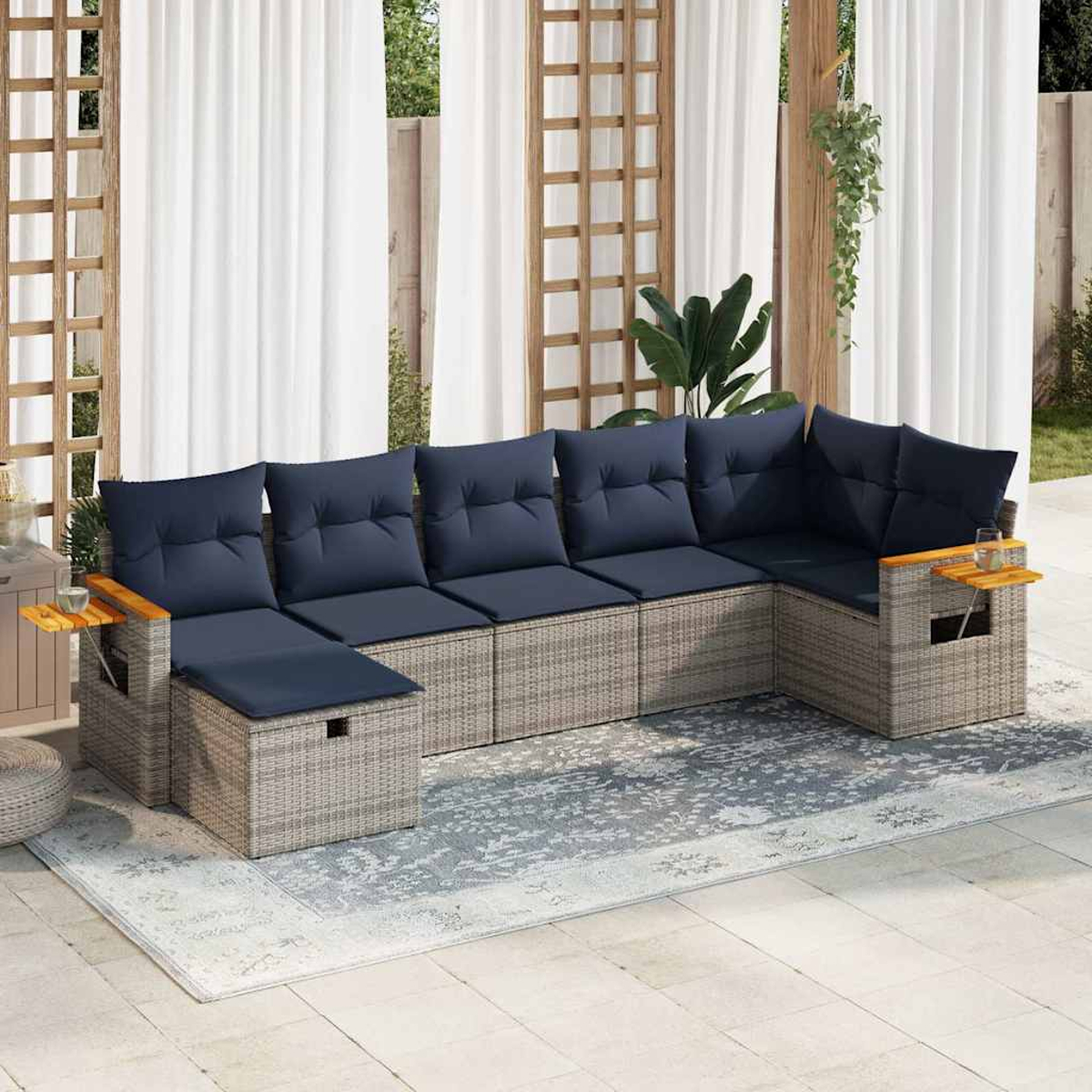 Outdoor-Ecksofa mit dunkelblauen Kissen, Beistelltischen und Teppich. Korbmuster.