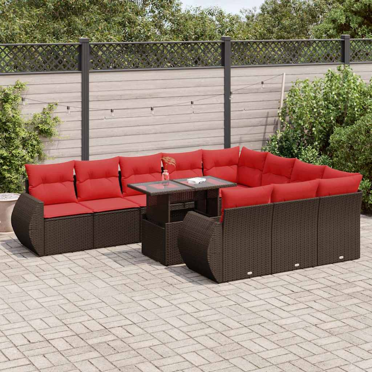 Eine Szene im Freien mit einem Rattan-Sofaset mit roten Kissen und einem Tisch. Die Szene ist auf einer Terrasse.