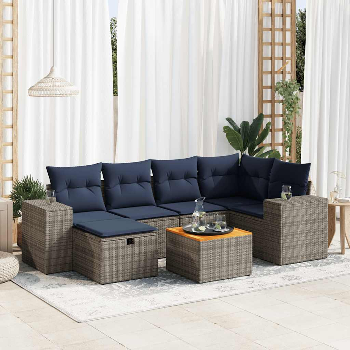 Ein Outdoor-Ecksofa mit marineblauen Kissen, einem Tisch und einem weißen Vorhang im Hintergrund.
