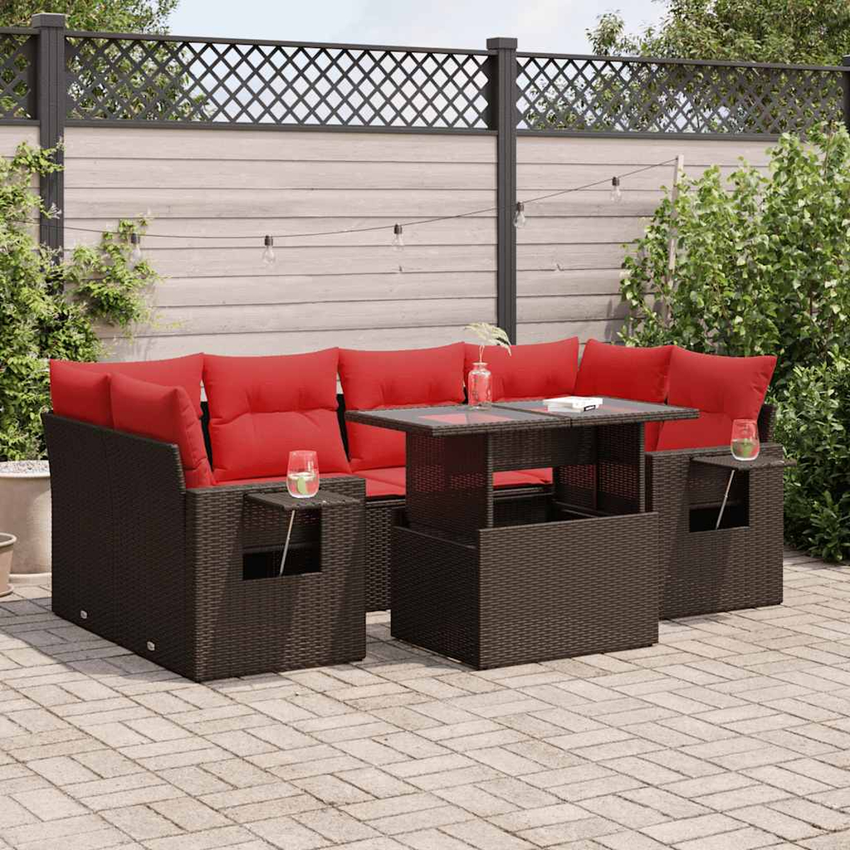 Ecksofa im Freien mit roten Kissen, einem Tisch und Beistelltischen auf einer Terrasse.