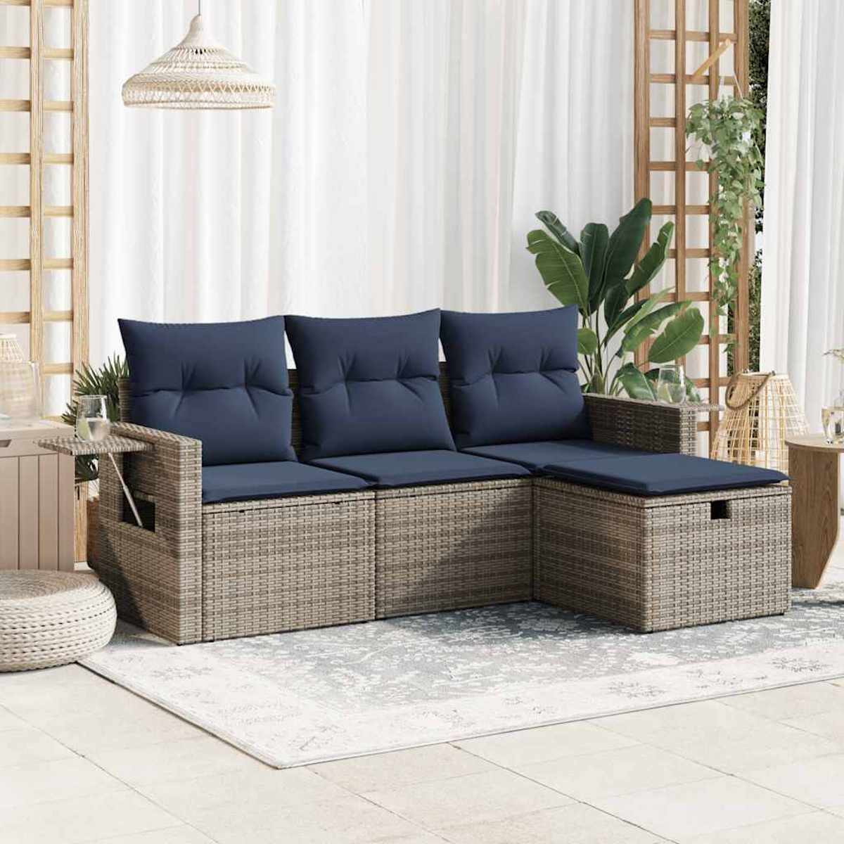 Outdoor-Ecksofa mit blauen Kissen, grauem Korbgeflecht und einem Beistelltisch, auf einem gemusterten Teppich.