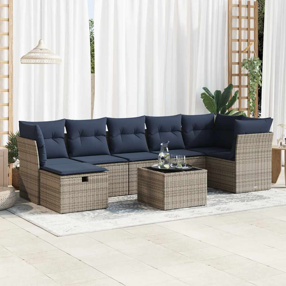 Ein Ecksofa für den Außenbereich mit blauen Kissen und einem quadratischen Couchtisch auf einem Teppich.