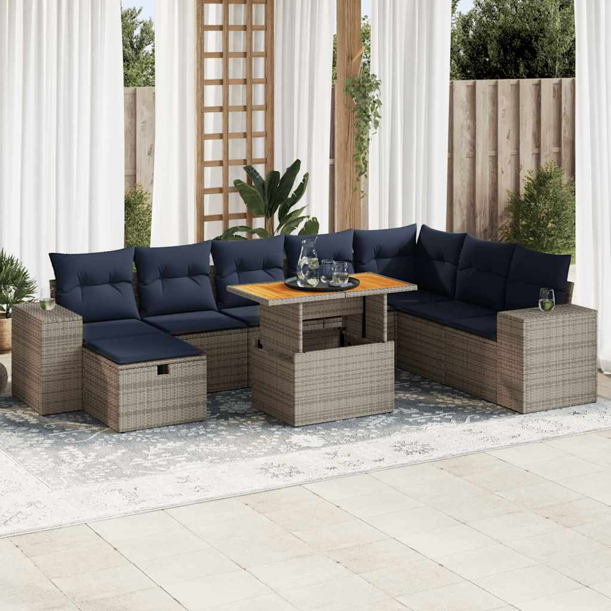Ein Gartenmöbel-Set mit Sofa, Tisch und Kissen, auf einer Terrasse platziert.