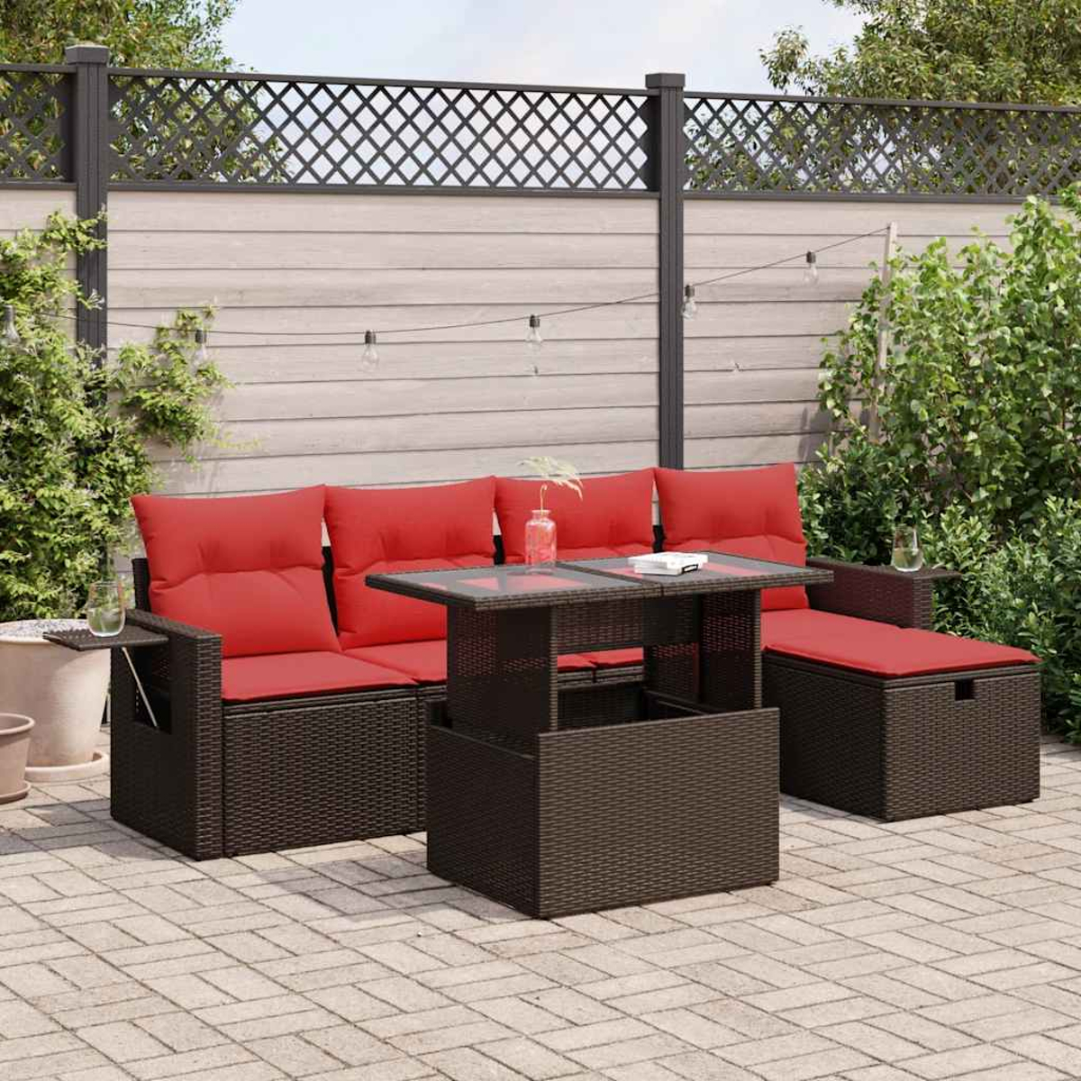 Ein Outdoor-Sitzbereich mit einer Eckcouch, einem Tisch und einem Ottoman. Alles ist braun mit roten Kissen.