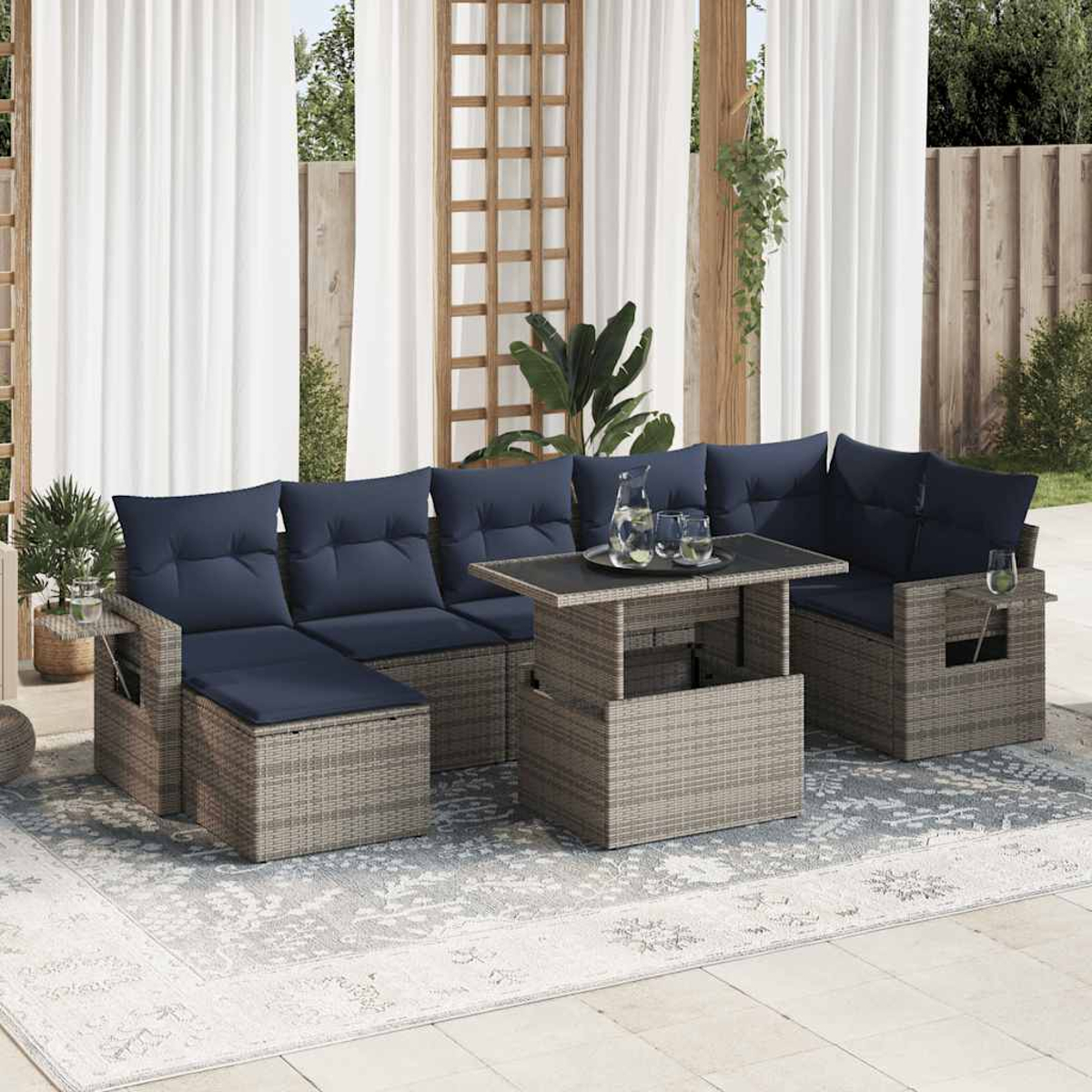 Terrassenmöbel-Set mit blauen Kissen, angeordnet auf einem gemusterten Teppich, mit einem Tisch in der Mitte.