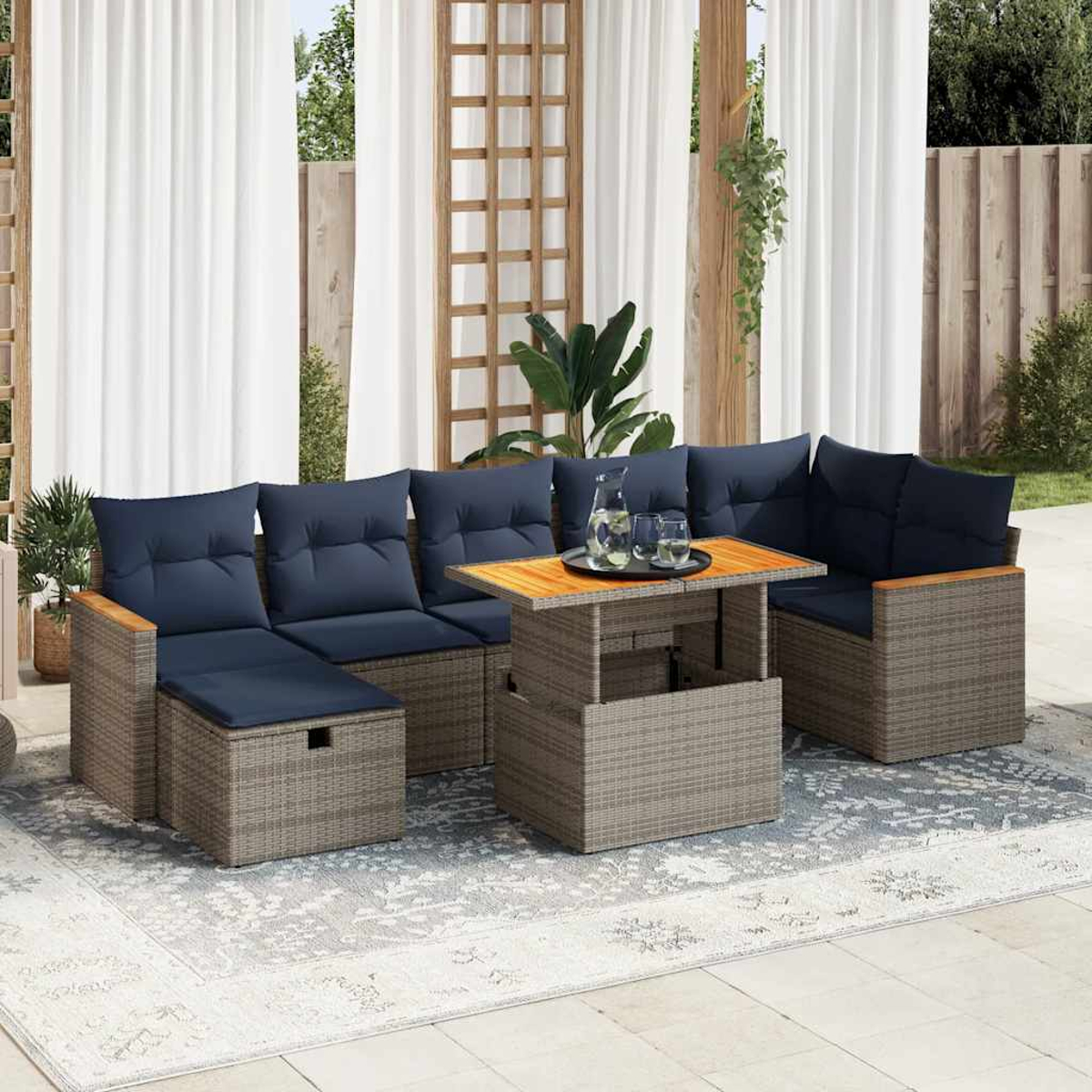 Outdoor-Ecksofa mit blauen Kissen und einem Tisch mit Holzplatte. Auf einem hellfarbigen Teppich platziert.