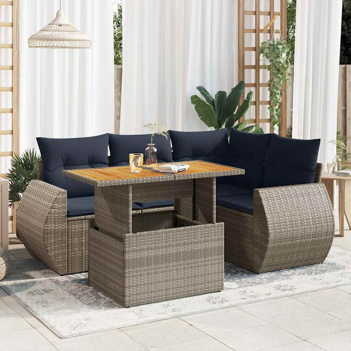 Geflochtenes Outdoor-Möbelset mit Tisch und blauen Kissen. Modernes Design mit weißem Vorhang.