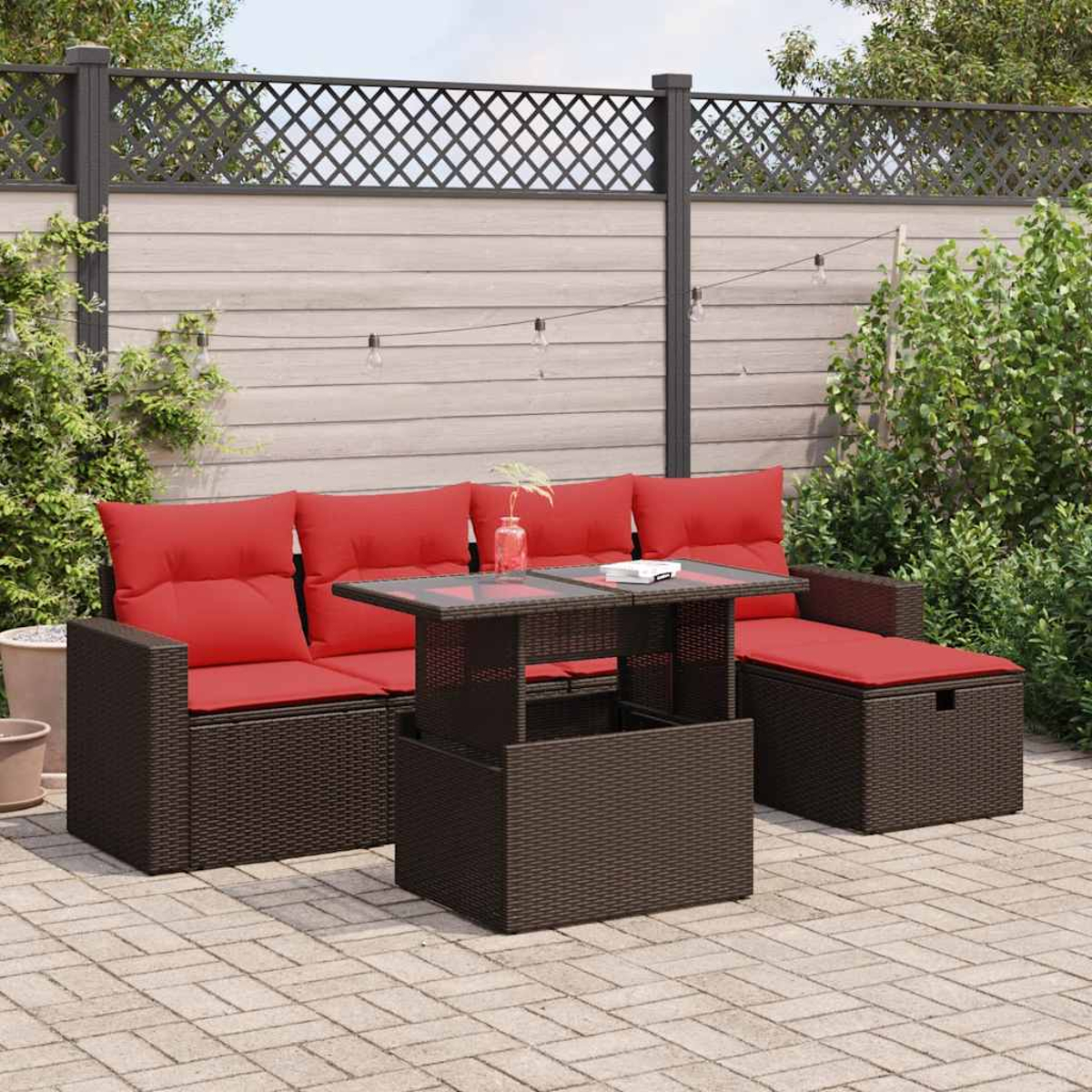 Ein Terrassenset mit Tisch, Sofa und Bank mit roten Kissen. Es ist ein sonniger Tag.