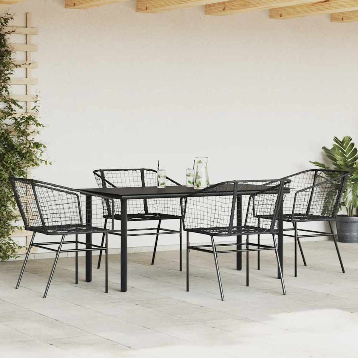 Terrassenset mit schwarzem Tisch und vier schwarzen Drahtstühlen. Der Hintergrund ist eine Terrasse.