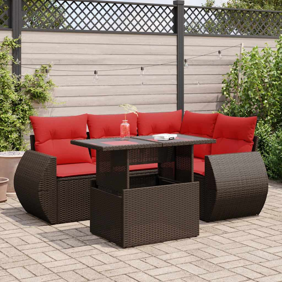 Braunes Outdoor-Ecksofa aus Weide mit roten Kissen, passendem Couchtisch, auf einer Backsteinterrasse, im Freien.