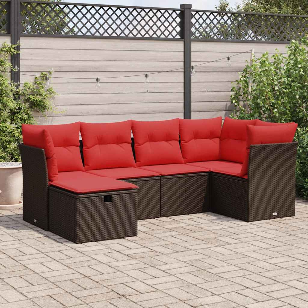 Outdoor-Szene: braunes Korbsessel mit roten Kissen. Hinterhof-Setting mit Stein-Terrasse.
