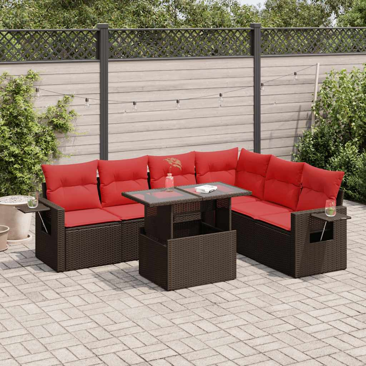 Ein Outdoor-Sofa mit roten Kissen und einem Tisch mit Hubplatte. Dunkelbrauner Webrahmen auf einer Ziegelterrasse.