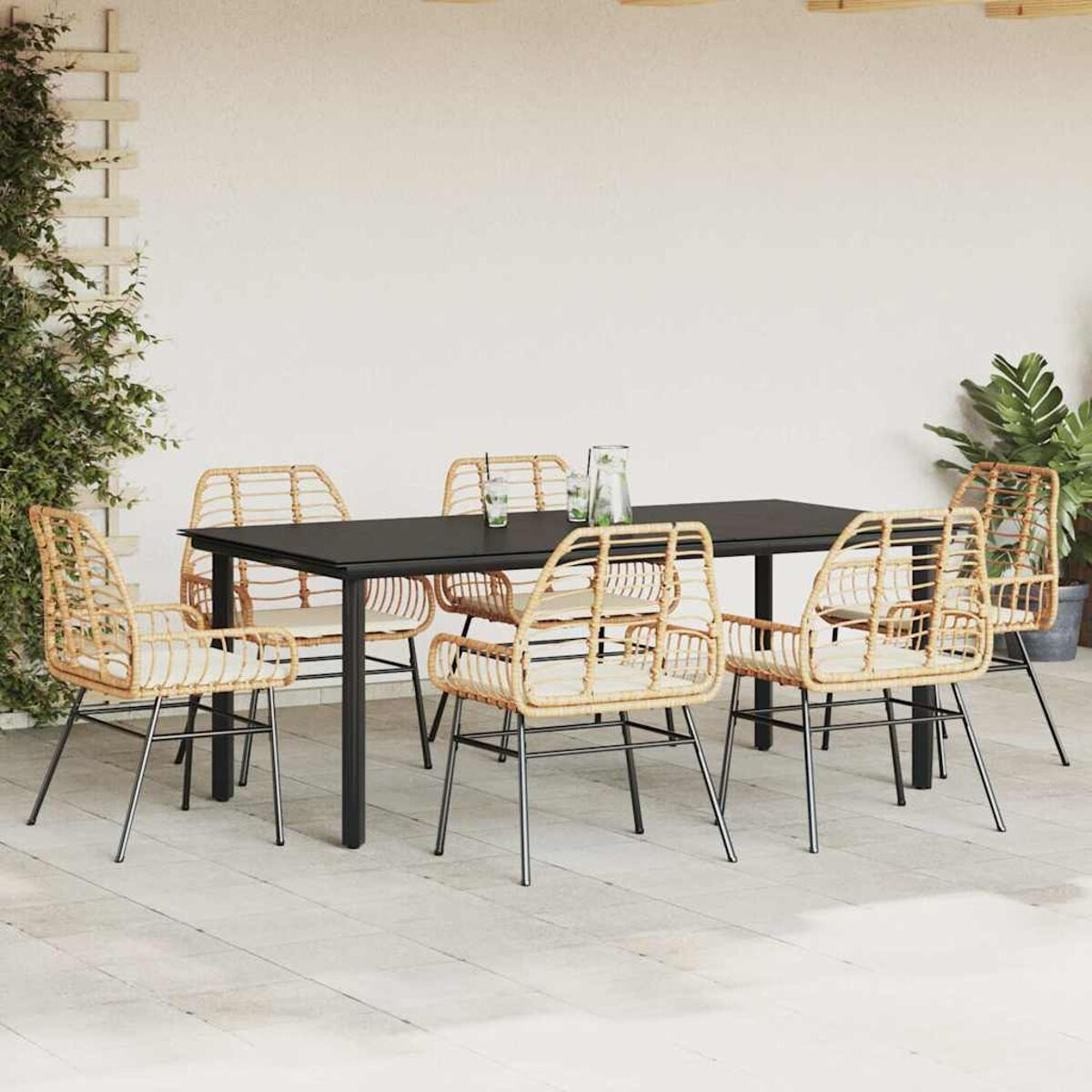 Essgruppe für den Außenbereich mit schwarzem Tisch und Rattanstühlen. Die Szene spielt auf einer Terrasse.