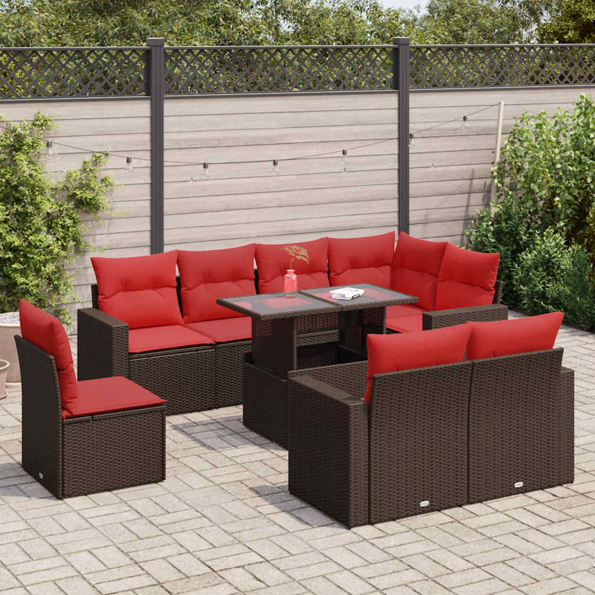 Rattan-Garnitur für draußen mit roten Kissen, auf Terrasse. Braune Farbe.