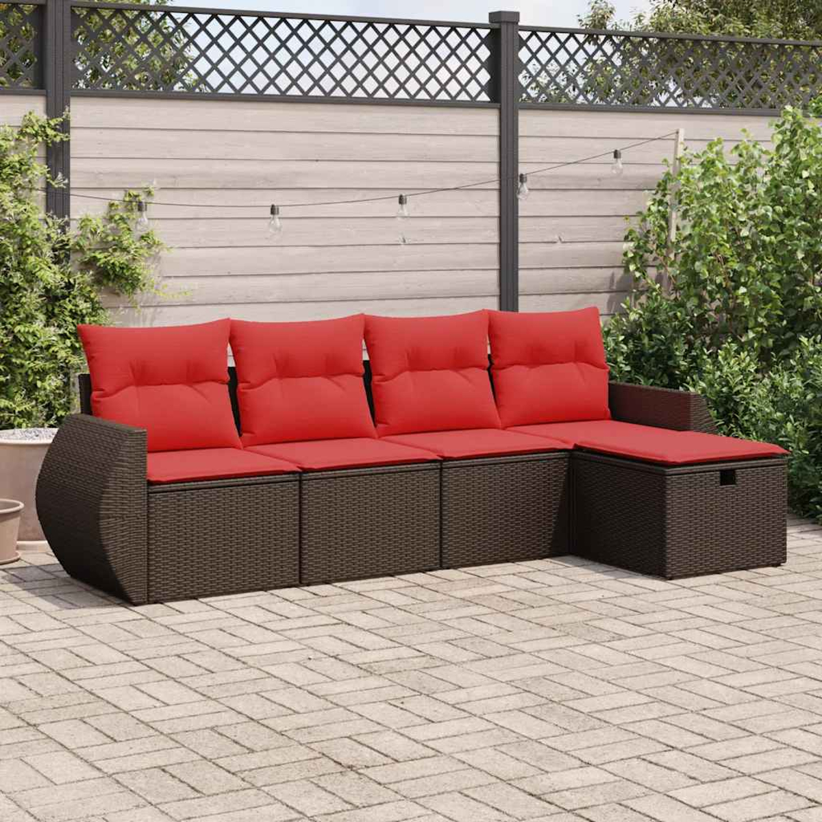 Gartenmöbel-Set mit roten Kissen und braunem Korbgeflecht auf einem Ziegelboden.