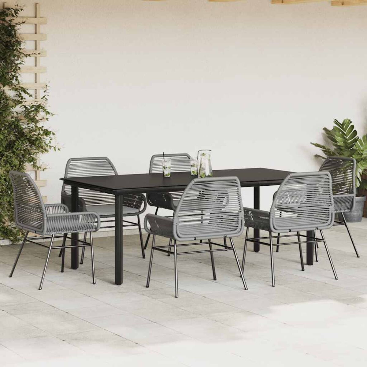 Essgruppe für den Außenbereich mit einem schwarzen Glastisch und sechs grauen Seilstühlen auf einer Terrasse.
