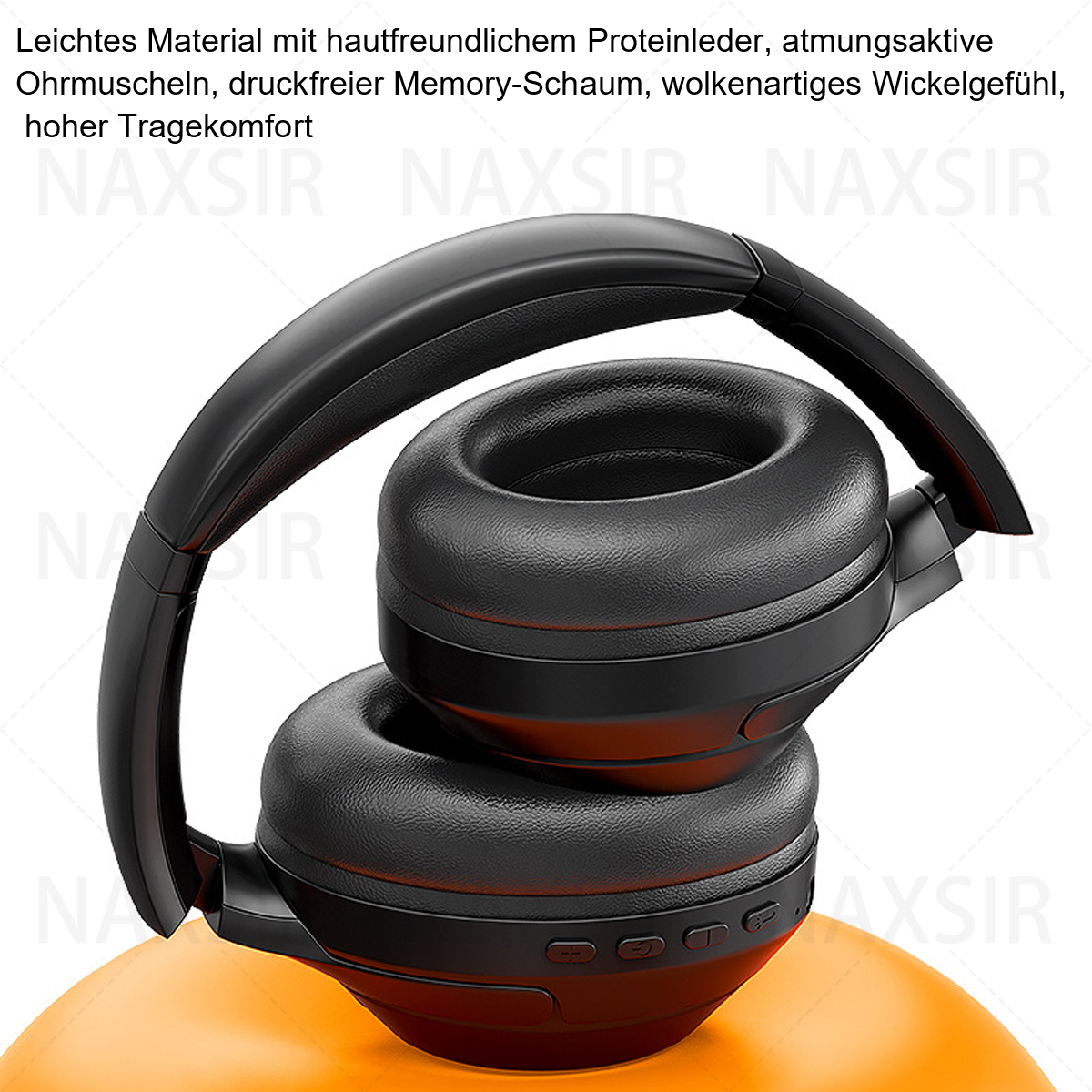 Schwarze Kopfhörer mit großen Ohrmuscheln, die auf einer orangefarbenen Oberfläche liegen. Das Design hat Knöpfe.