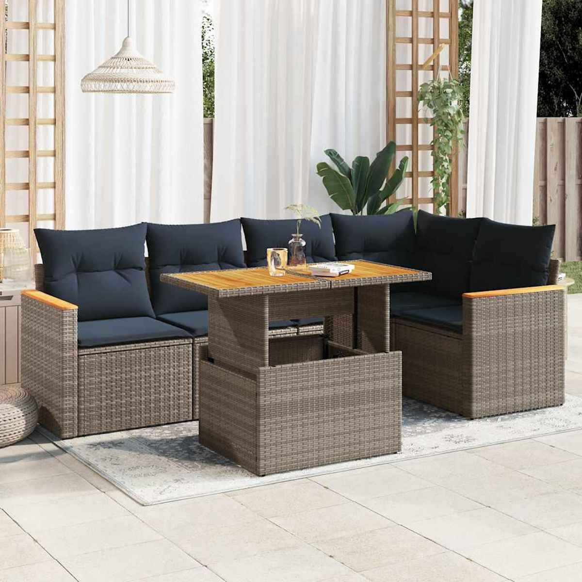 Ein graues Outdoor-Ecksofa aus Korbgeflecht mit schwarzen Kissen und einem Holztisch.