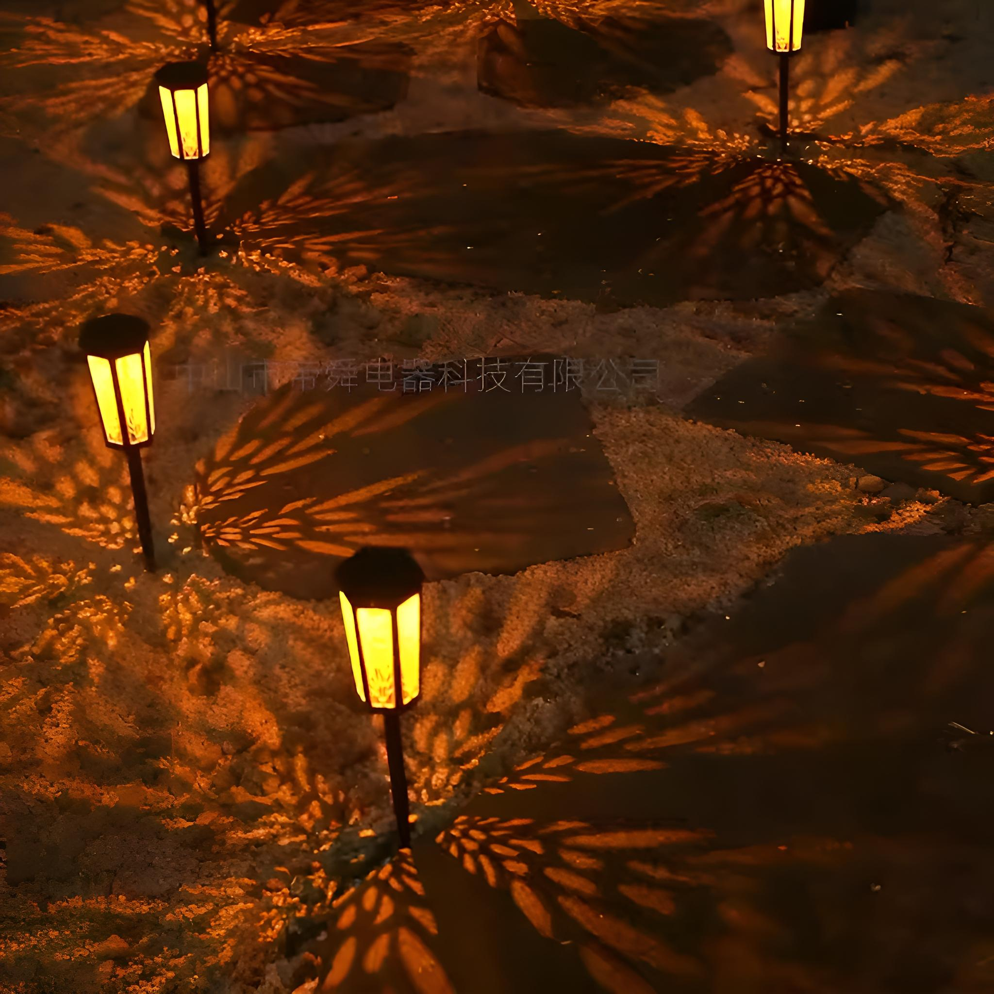 Mehrere Solar-Gartenleuchten beleuchten einen Weg. Die Lichter werfen ein Blättermuster auf den Boden. Die Lichter sind schwarz.