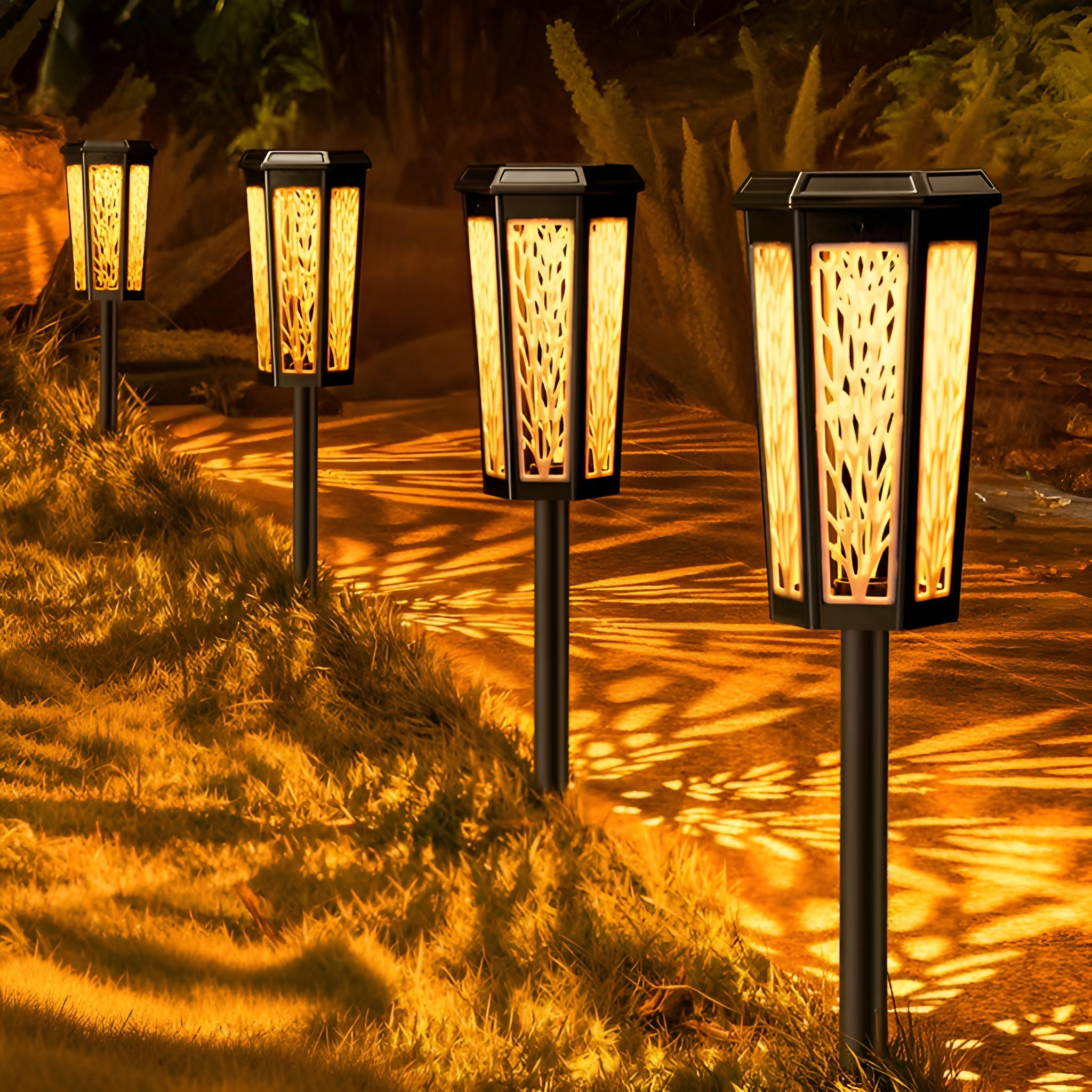 Mehrere Solar-Gartenleuchten, die Gras beleuchten. Die Lichter sind schwarz und der Hintergrund ist eine grasbewachsene Fläche.