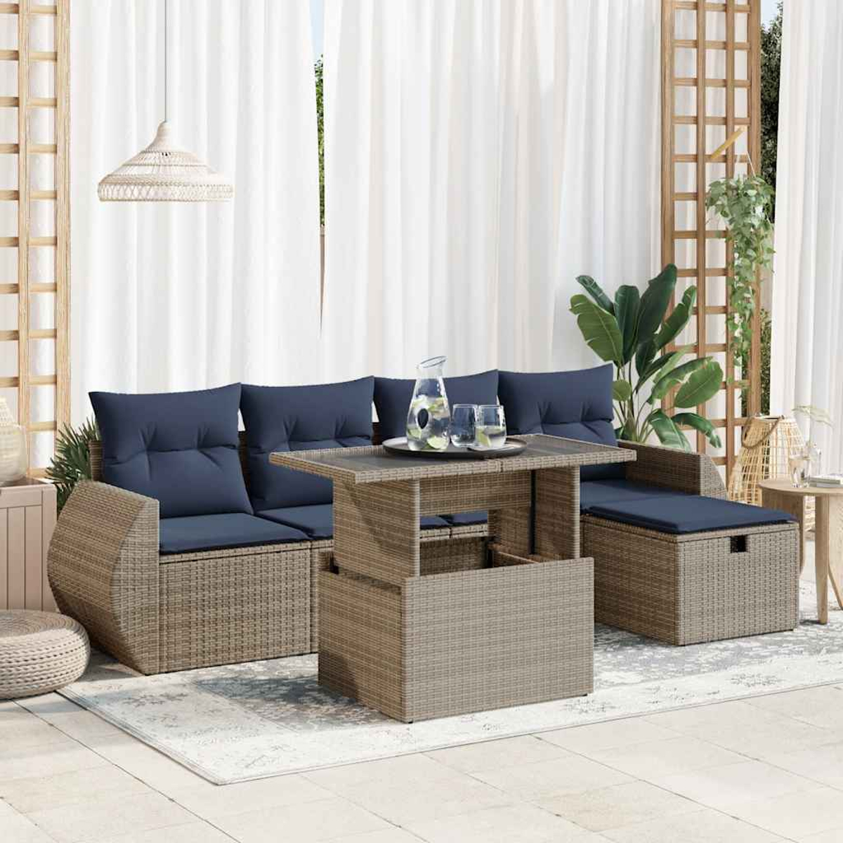 Outdoor-Rattan-Sofagarnitur mit blauen Kissen und einem Tisch mit Hubfunktion. Weiße Vorhänge im Hintergrund.