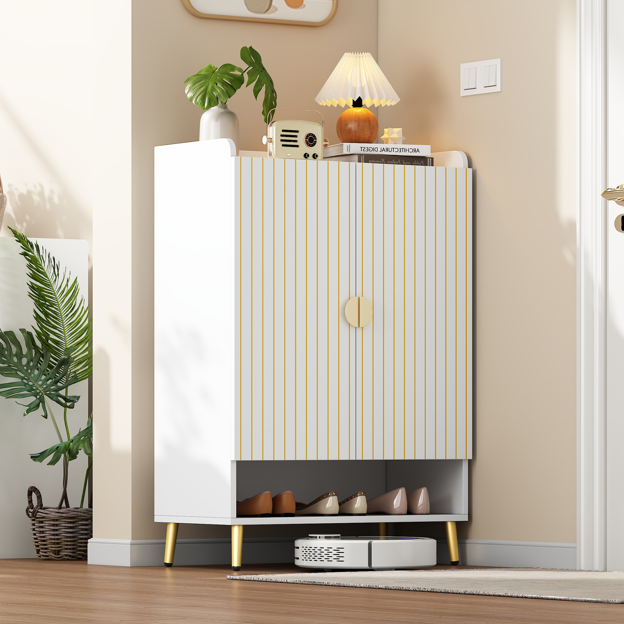 Weißer Schrank mit goldenen Streifen und Griff. Darunter ein Roboterstaubsauger.