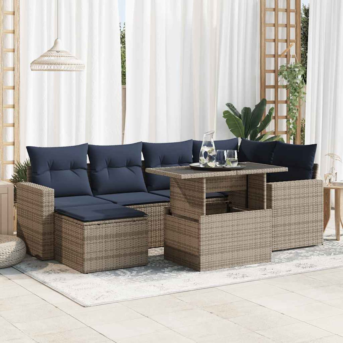 Geflochtene Outdoor-Eckgarnitur mit Couchtisch mit Hubfunktion, blauen Kissen und gemustertem Teppich.