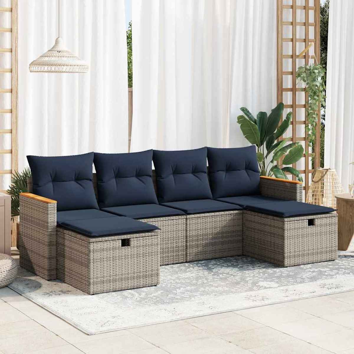 Disposición de patio al aire libre con seccional de ratán gris con cojines azules, una mesa de madera y una alfombra.