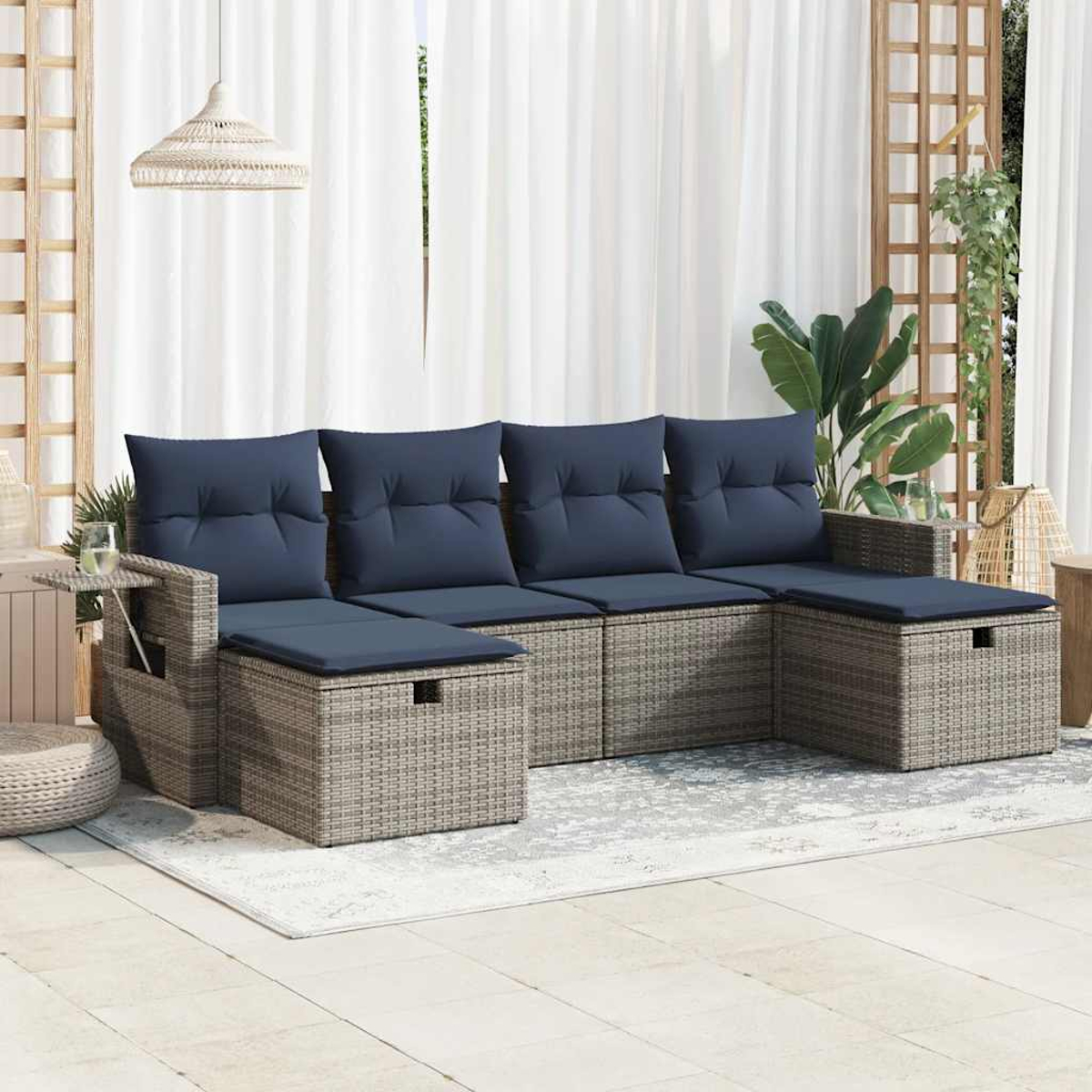 Moderne Außenterrasse mit grauem Ecksofa aus Korbgeflecht und blauen Kissen. Mit Teppich und Pflanzen.