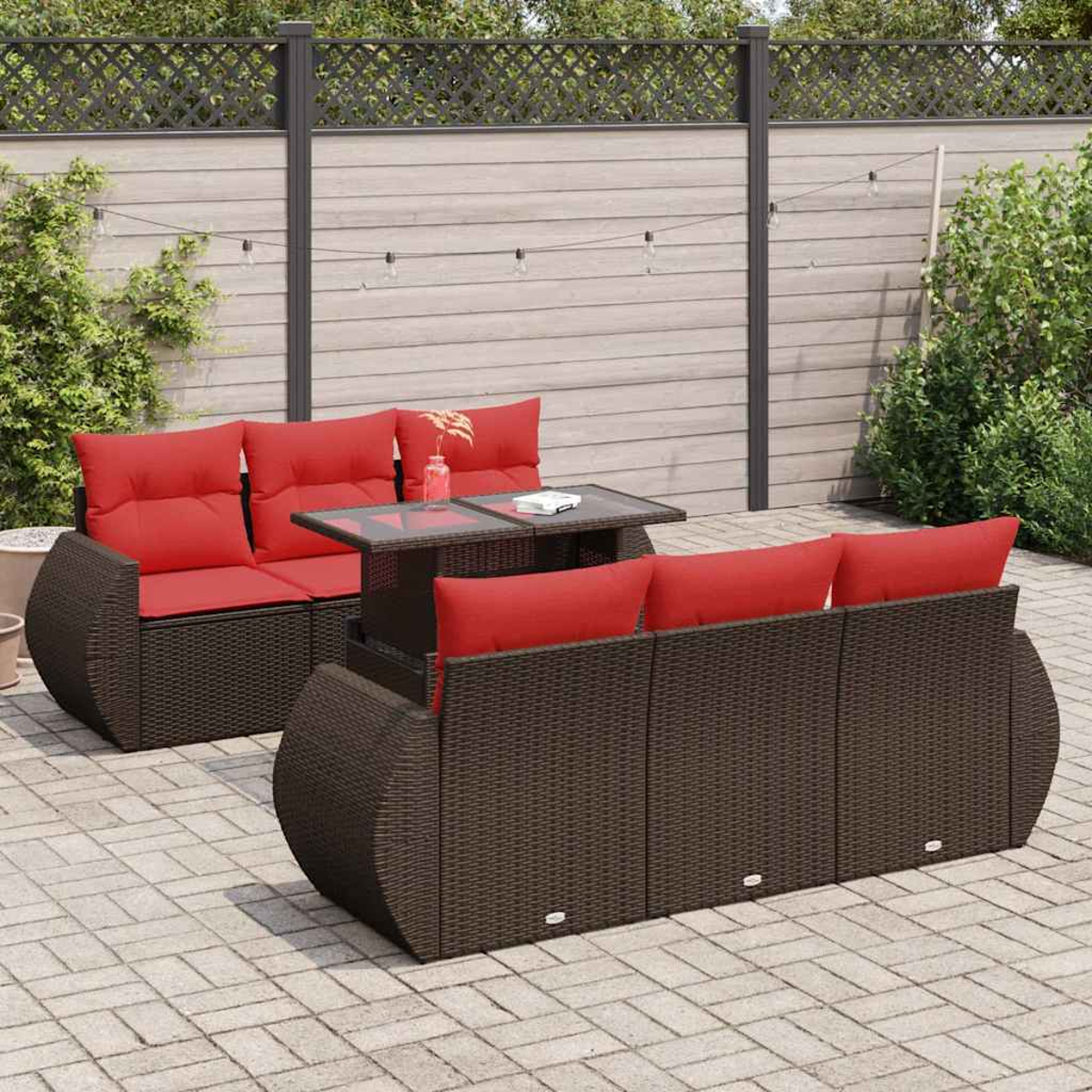Outdoor-Sofagarnitur mit roten Kissen und einem Tisch mit Glasplatte. Steht auf Ziegelpflaster.