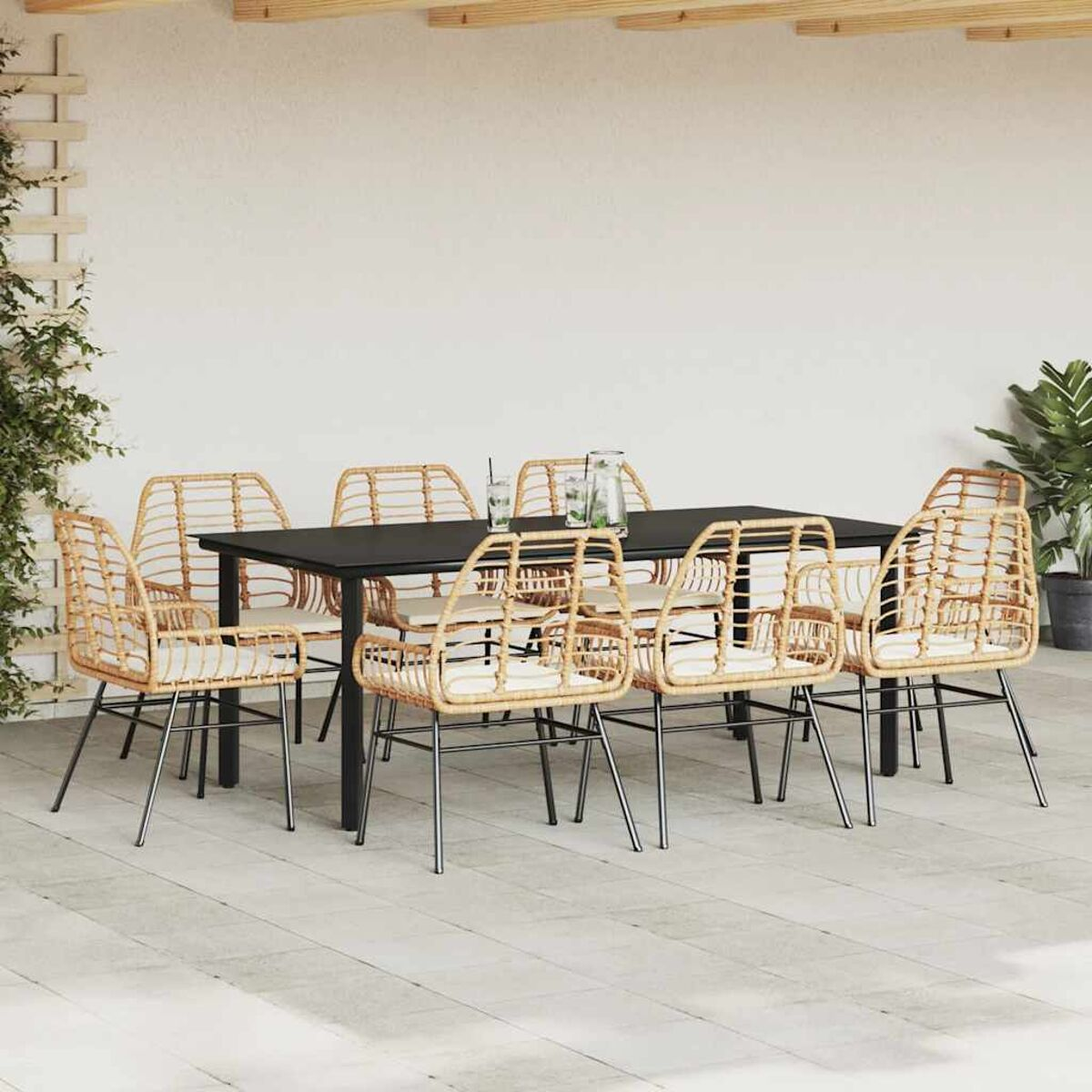Esstisch mit Stühlen auf einer Terrasse. Stühle sind gewebt mit weißen Kissen. Schwarzer Tisch.