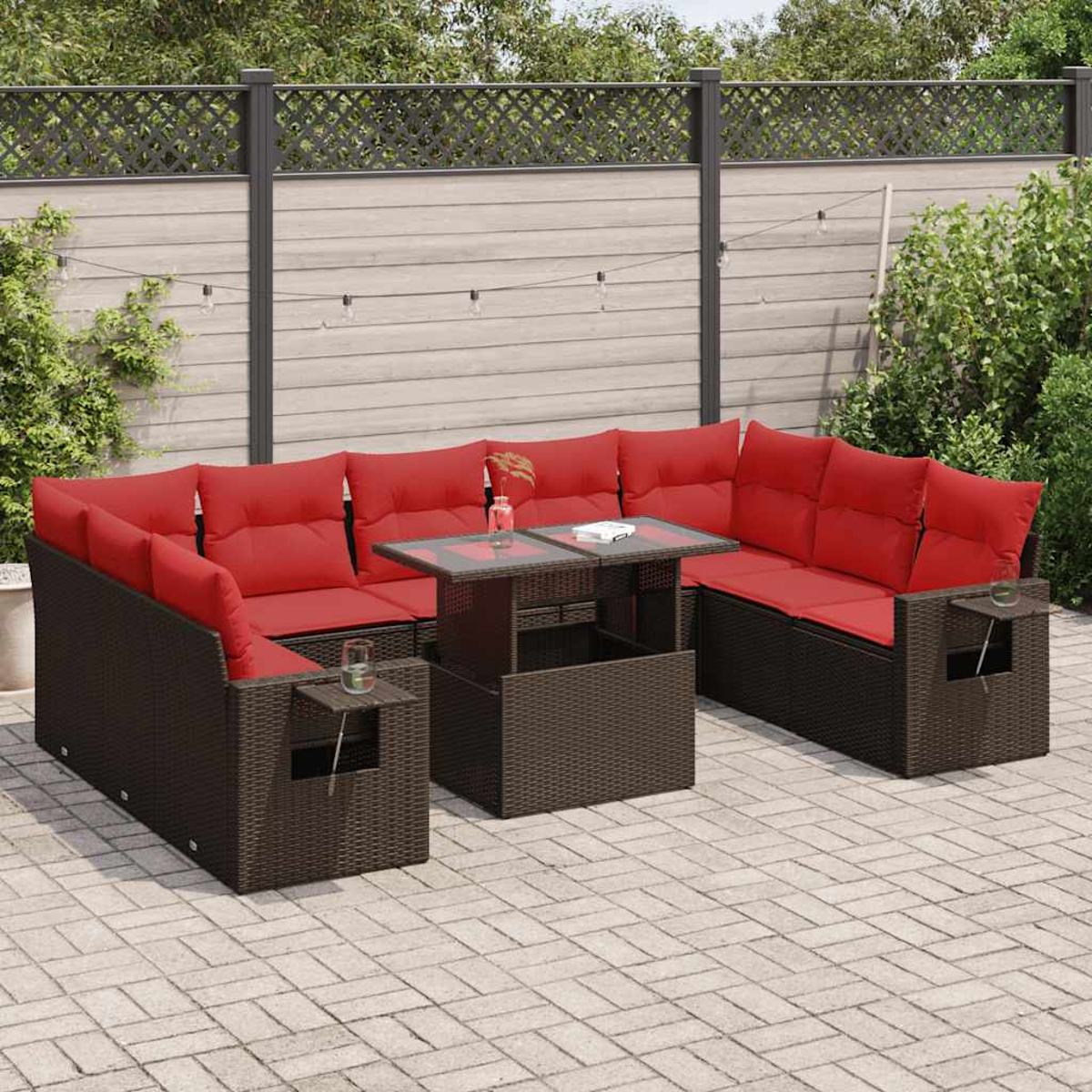 Braunes Rattan-Ecksofa mit roten Kissen und einem Holztisch. Hintergrund aus Ziegelpflasterung.