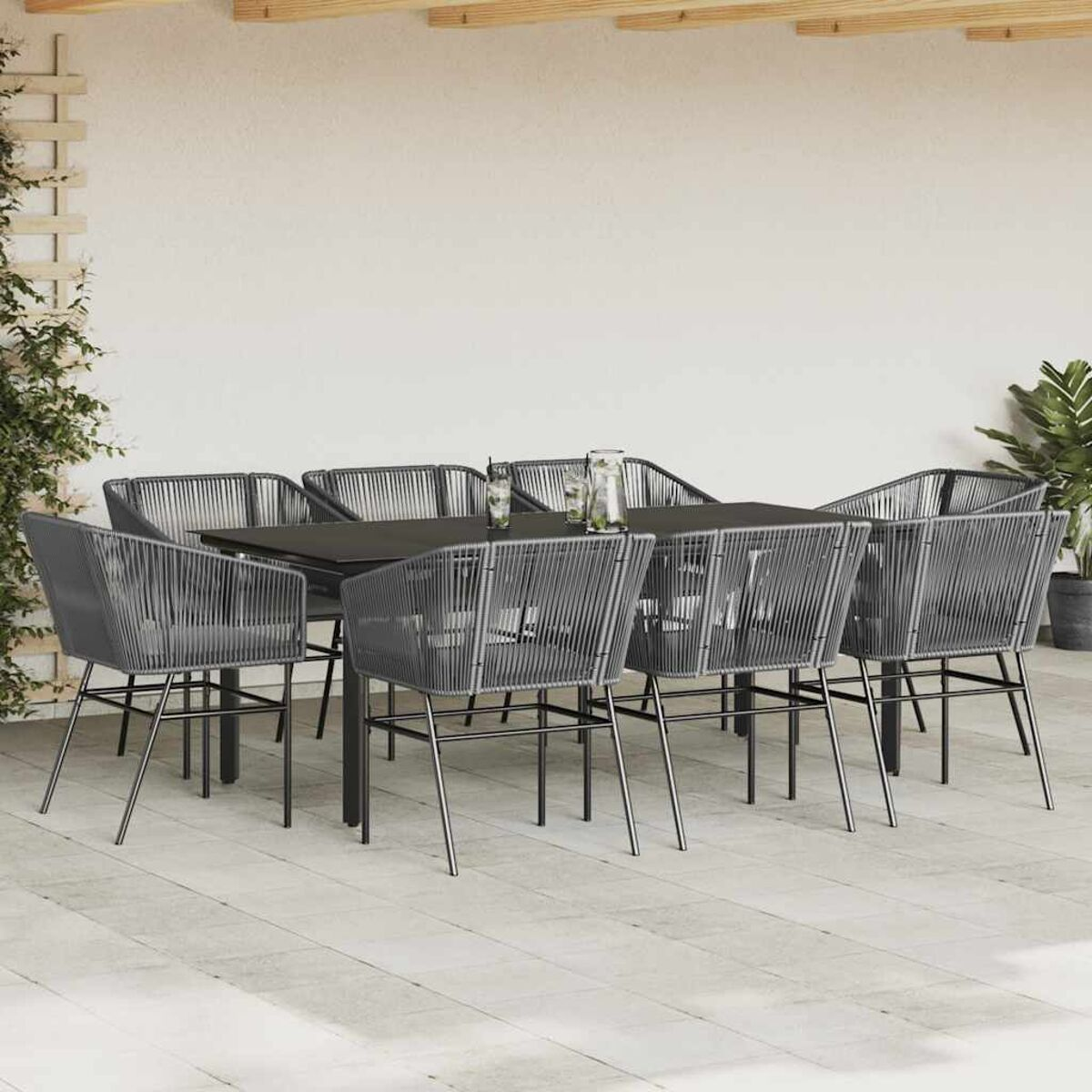 Essgruppe im Freien mit grauen Stühlen und einem schwarzen Tisch. Die Szene ist auf einer Terrasse.